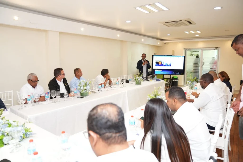 Roberto Valentín Guerrero presenta la página web de Fedomu en una pantalla ante los alcaldes
