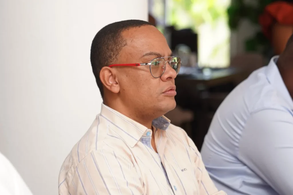Hipólito Cabral, alcalde de Guayabal, de perfil con lentes y camisa clara, atento a la asamblea