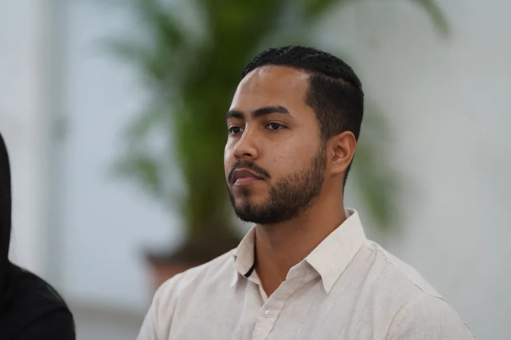 Erick Santana sentado durante la asamblea