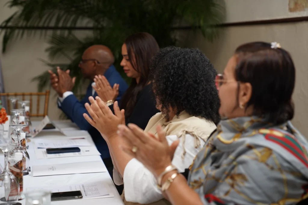 Participantes sentados a la mesa aplauden