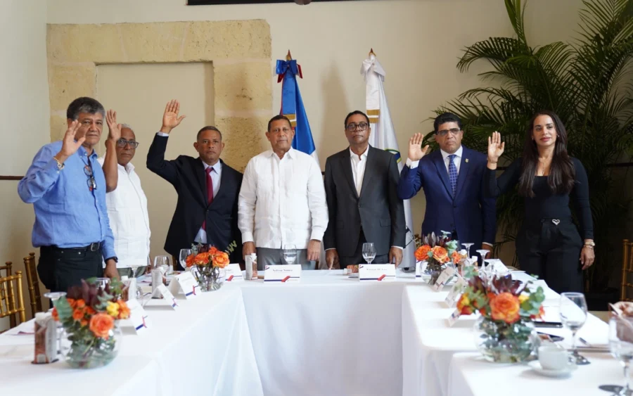 Integrantes de la directiva de Fedomu Región Ozama de pie con la mano derecha en alto durante el juramento