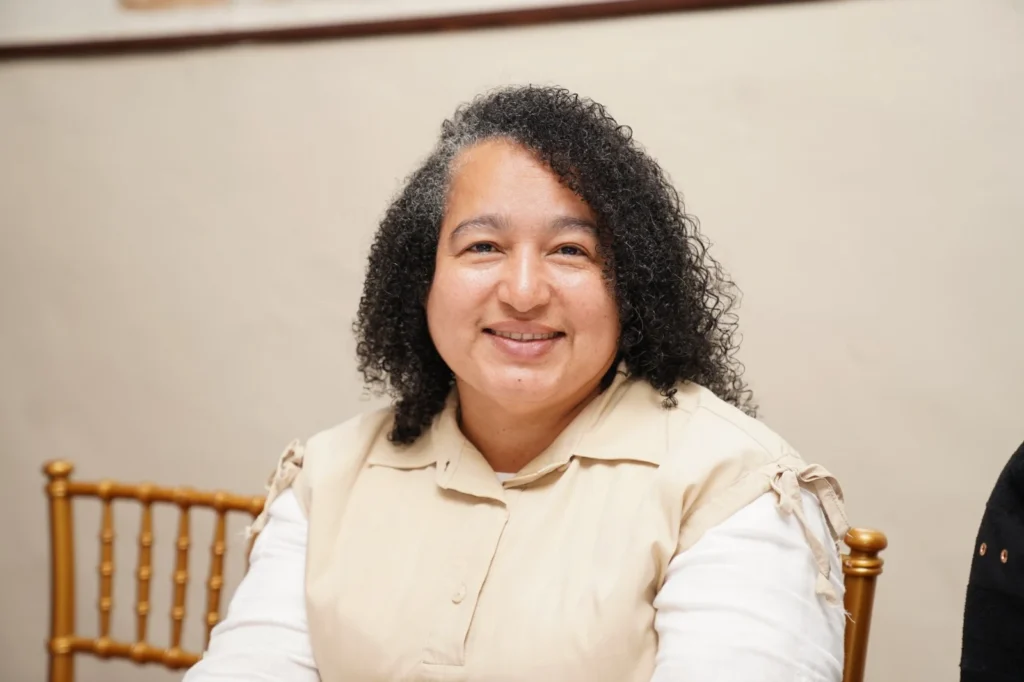 Yissell Santana sonríe sentada durante la asamblea